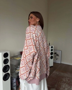 Close-up of pink and cream floral knit pattern on oversized long-sleeve sweater