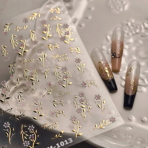 Detalle de pegatinas de uñas con relieve de flores y hojas doradas M-1013