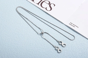 Detailed view of silver snake chain necklace featuring infinity charms and sliding buckle