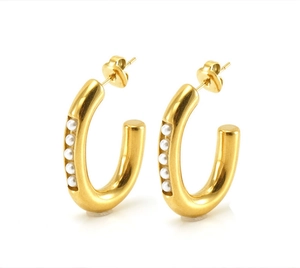 Close-up of gold-plated U-shaped earrings featuring five elegant white pearls in detail