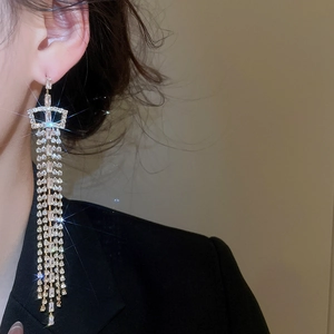 Elegant long silver tassel earrings with cubic zirconia worn by a model for evening style