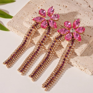 Macro detail of long flower fringe earrings with pink rhinestones and purple tassel chains