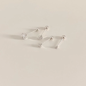 Minimalist 925 sterling silver zircon stud earrings set on a warm beige background