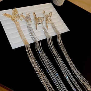 Détail des pinces à cheveux papillon dorées et argentées avec de longs glands pendants