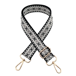 Close-up of diamond pattern wide woven strap with light gold lobster claw clasps
