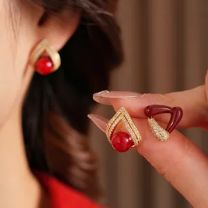 Boucles d'oreilles triangulaires dorées 18k avec pierre rouge et zircons étincelants