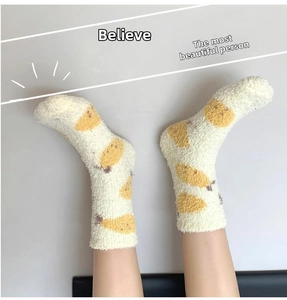 Detailed texture of thick cream coral fleece socks featuring yellow banana patterns