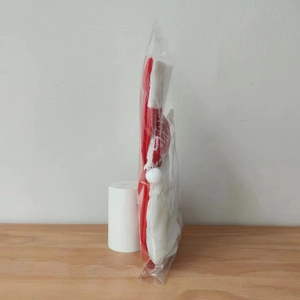 Close-up of a red knitted Christmas stocking with plush white trim in clear packaging