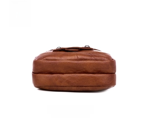 Detail view showing the flat bottom and textured lychee pattern of the brown PU leather bag