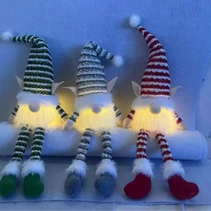 Three glowing Christmas gnomes with striped hats and warm LED lights for holiday decor