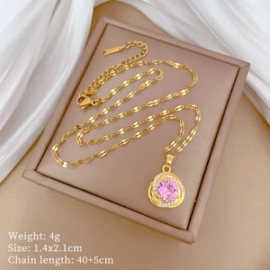 Detailed view of a gold spiral pendant with a pink gemstone and diamond accents