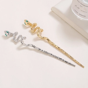 Snake shaped hair pins in gold and silver metal with green gemstone eyes detail