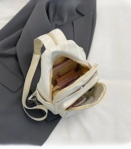 Dettaglio della borsa a tracolla beige in nylon con interno spazioso e tasche multiple