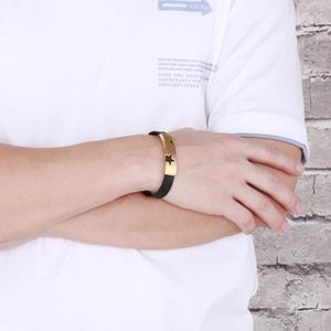 Detail of woven bracelet with gold metal plate featuring three star cutouts on wrist