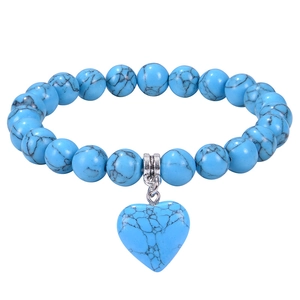 Dettaglio del bracciale di perle turchesi blu cielo con ciondolo a cuore e texture