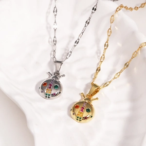 Close-up of gold and silver ladybug pendants with colorful crystals on metal chains