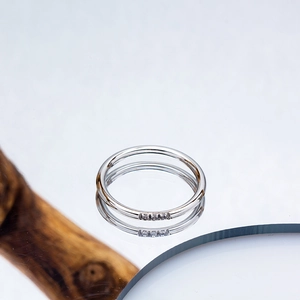 Macro detail of slim silver titanium ring with three inlaid mini diamonds