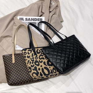 Three stylish women's tote bags in diverse textures displayed on a blazer