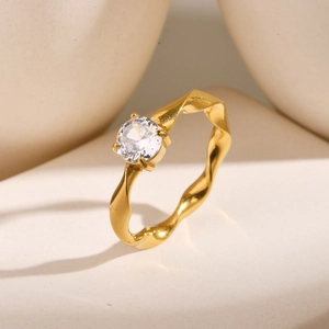Detail of gold Mobius ring featuring a single sparkling round zircon on a minimalist band