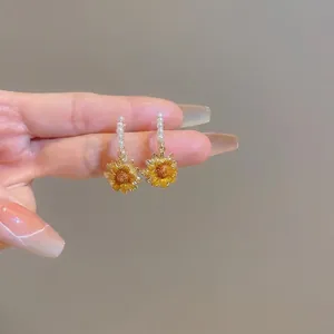 Elegant gold-plated sunflower stud earrings featuring white pearls and yellow petals