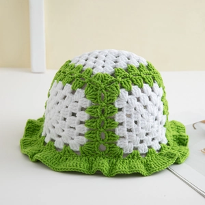 Close-up of handmade knit bucket hat with green ruffle edges and hollow-out texture