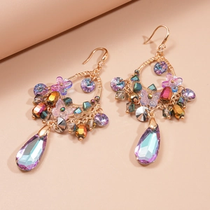 Detailed close-up of vintage gold earrings with colorful crystals and butterfly charms