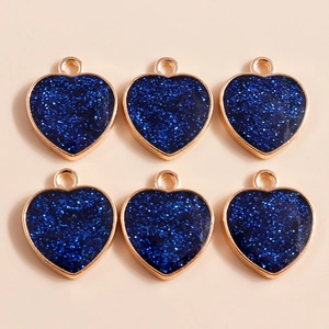 Detail of blue glitter heart charms with gold plating for DIY jewelry making