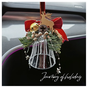 Close-up of glass Christmas bell with red velvet bow and wooden reindeer car pendant