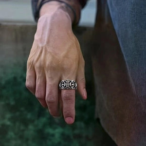 Close-up of vintage trident ring in silver with gothic cross and textured details