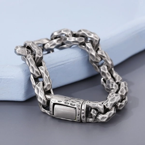 Detailed macro view of vintage silver hammer-patterned links on a punk steel bracelet