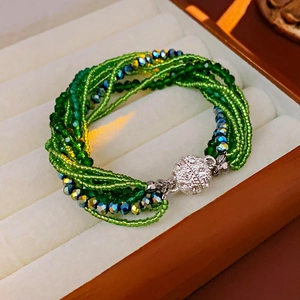 Détail du bracelet multicouche en perles de cristal vert avec fermoir magnétique strass