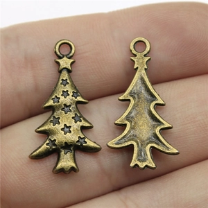Antique bronze Christmas tree metal pendants showing front and back views on finger