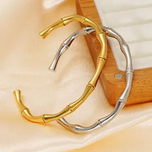 Bamboo style 18K gold and silver plated open bracelets set on silk and wooden display