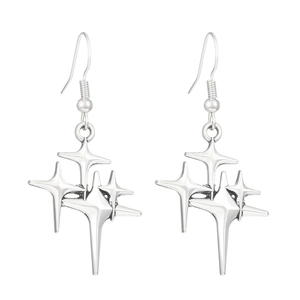 Close-up of polished silver starburst earrings featuring multiple layered four-pointed stars