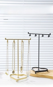 Detail of metal jewelry rack with heart-shaped glass base for necklaces and rings