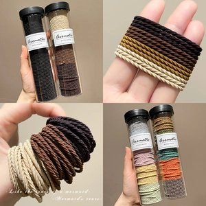 Spiral twisted elastic hair ties in transparent storage tubes for thick ponytails
