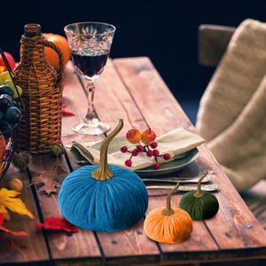 Velvet pumpkin decorations in blue, orange and green with gold stems for festive home decor