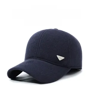 Detail of navy blue winter baseball cap with ear flaps and metallic triangle logo
