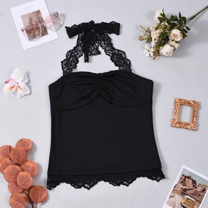 Detailed flat lay of a black lace halter top featuring backless tie design and trim