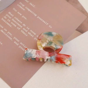 Close-up of marble pattern acetate hair claw clip with golden Amy Bear handmade logo