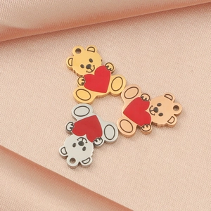 Three cute metal bear charms with red hearts on pink satin in gold silver rose gold