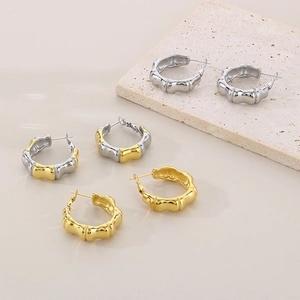 Detail of bamboo texture earrings in gold, silver, and two-tone finishes on stone