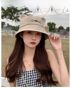 Outdoor shot of a beige cat ear sun hat for girls with cute embroidered whiskers