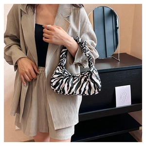 Detail of a chic zebra print cloud bag with a unique pleated shoulder strap design