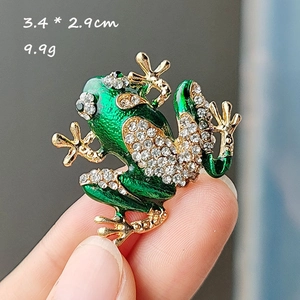 Detail view of a green enamel frog brooch with rhinestones showing dimensions 3.4 x 2.9cm