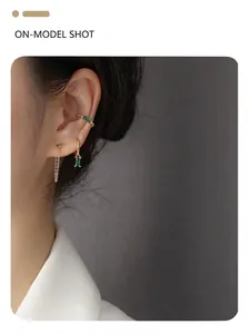 Detail of S925 silver emerald earrings and ear cuff on model with luxury gold plating