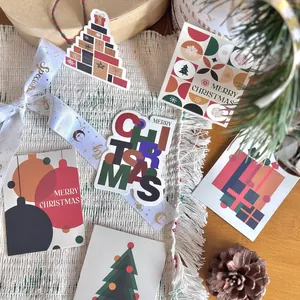 Festive Christmas gift tags and cards with creative cartoon holiday patterns on table