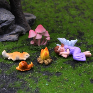 Miniature flower fairy garden set with sleeping angel, squirrel, snail, and campfire figurines