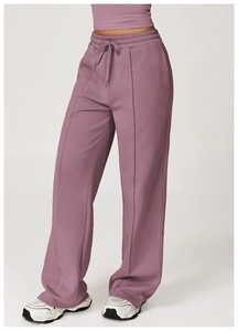 Detail of high-waisted purple sweatpants with drawstring and vertical seam stitching