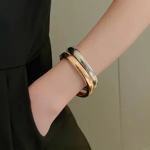 Polished gold and silver minimalist bangles in a high-gloss finish for a luxury look